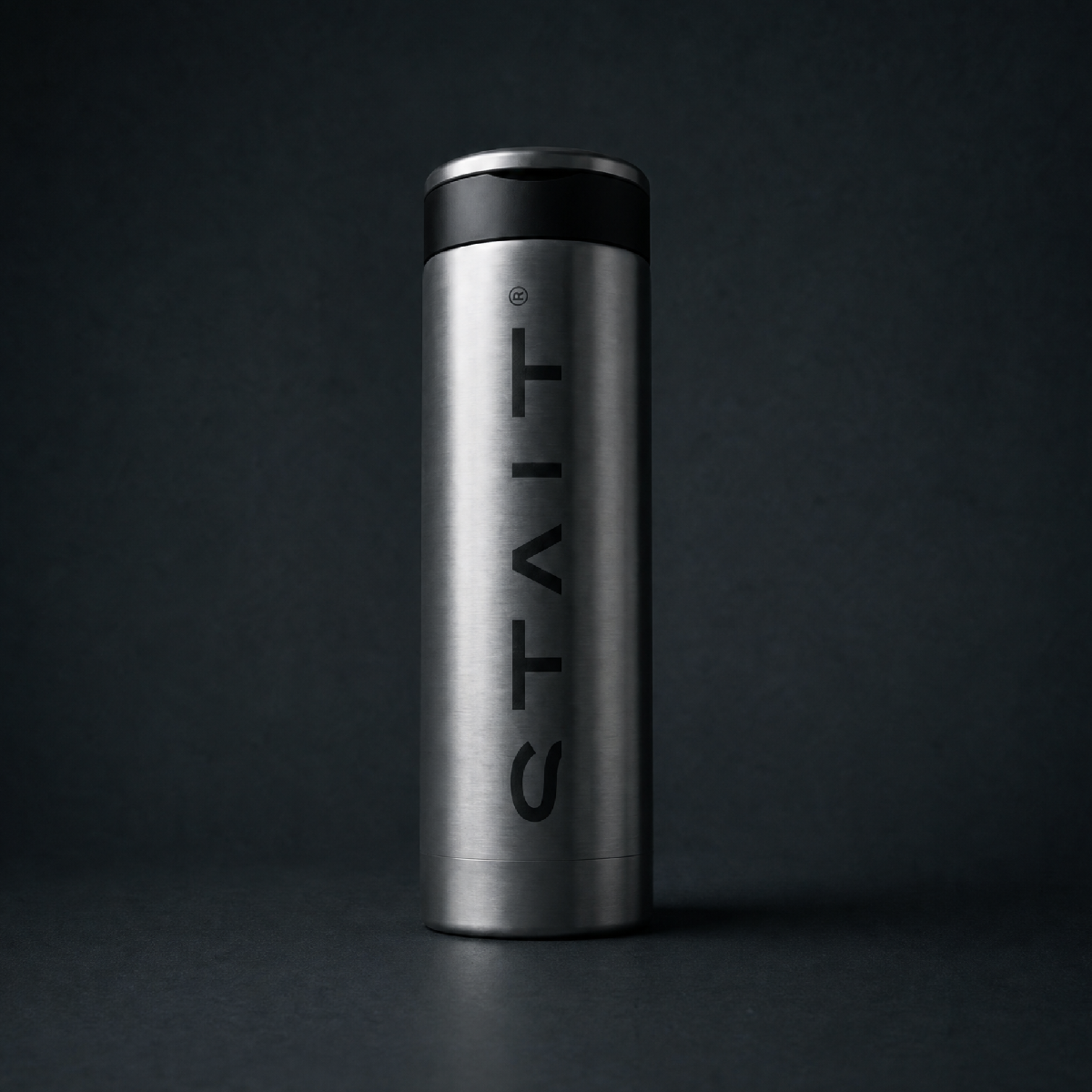 Silver flask with 'STAIT' branding on a black background.